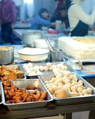 Trays of fresh kachori and jalebi at a sweet shop counter